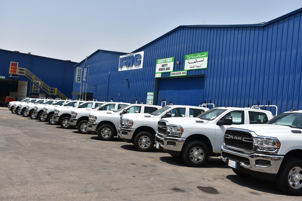White utility service trucks lined up outside the FHC Manufacturing facility in Saudi Arabia